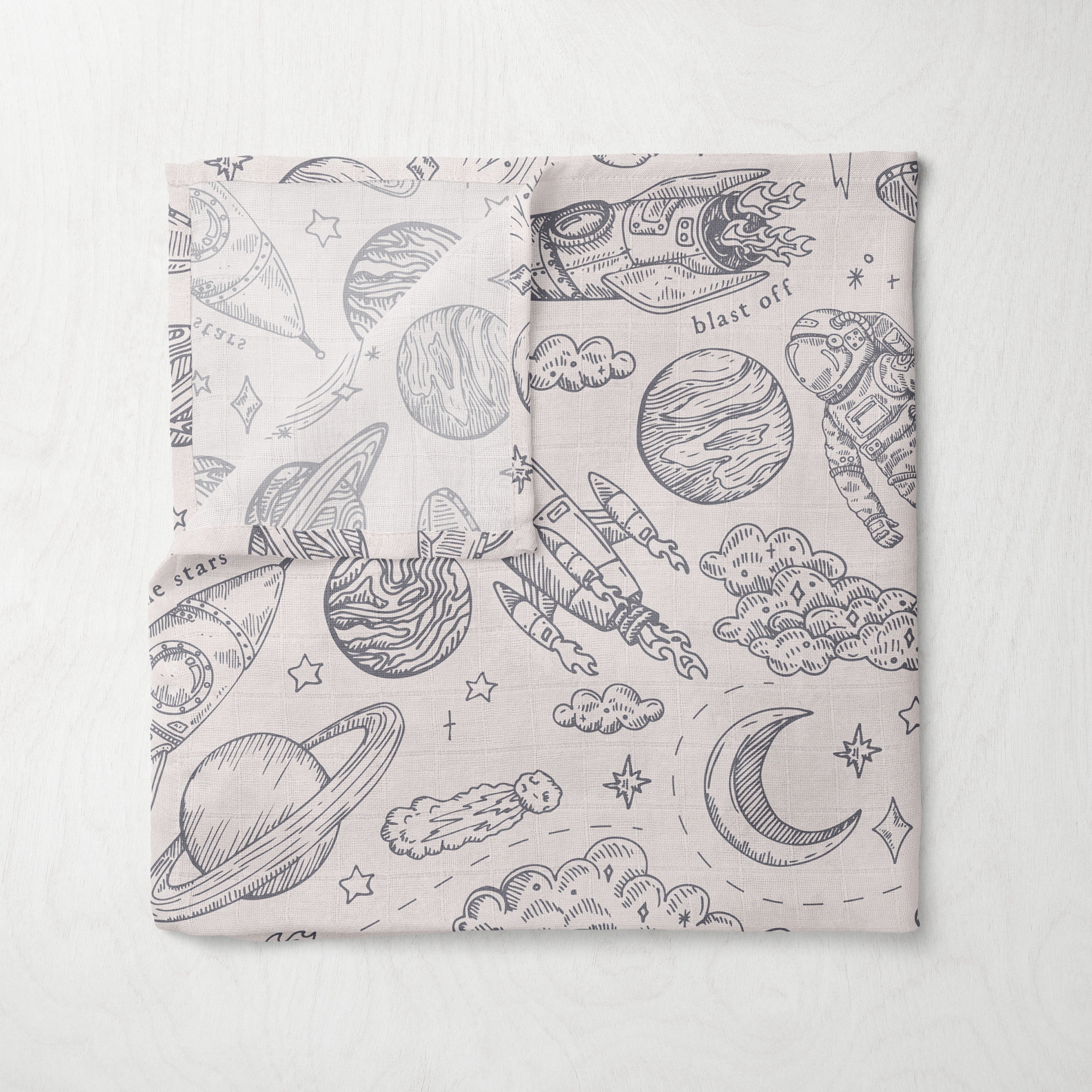 muslin fabric swaddle with space-themed pattern on a white background