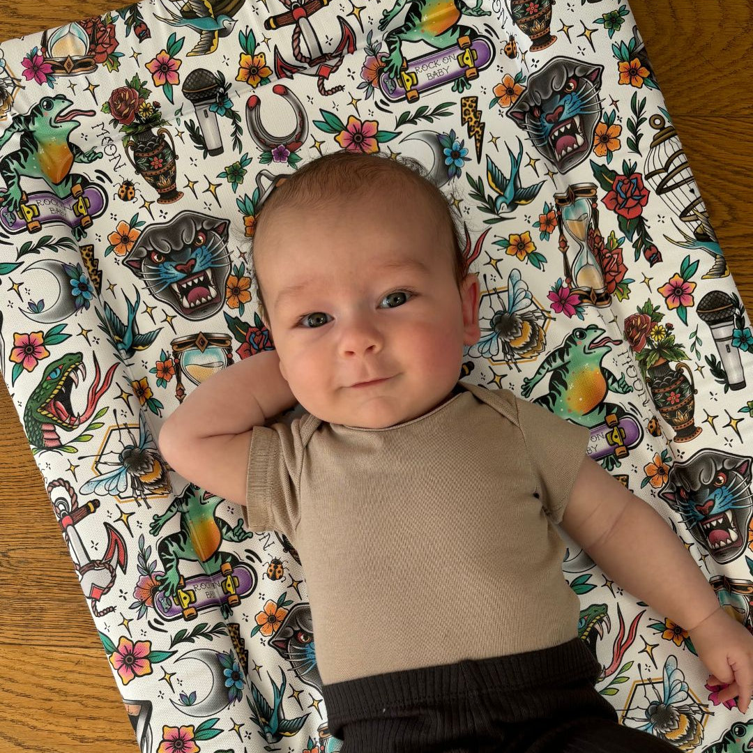 Baby lying on a alternative tattoo themed changing mat